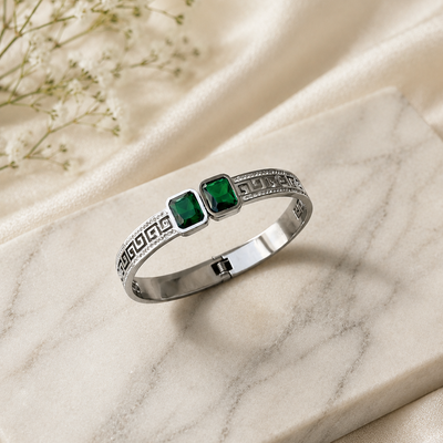 Silver bangle with green gemstones