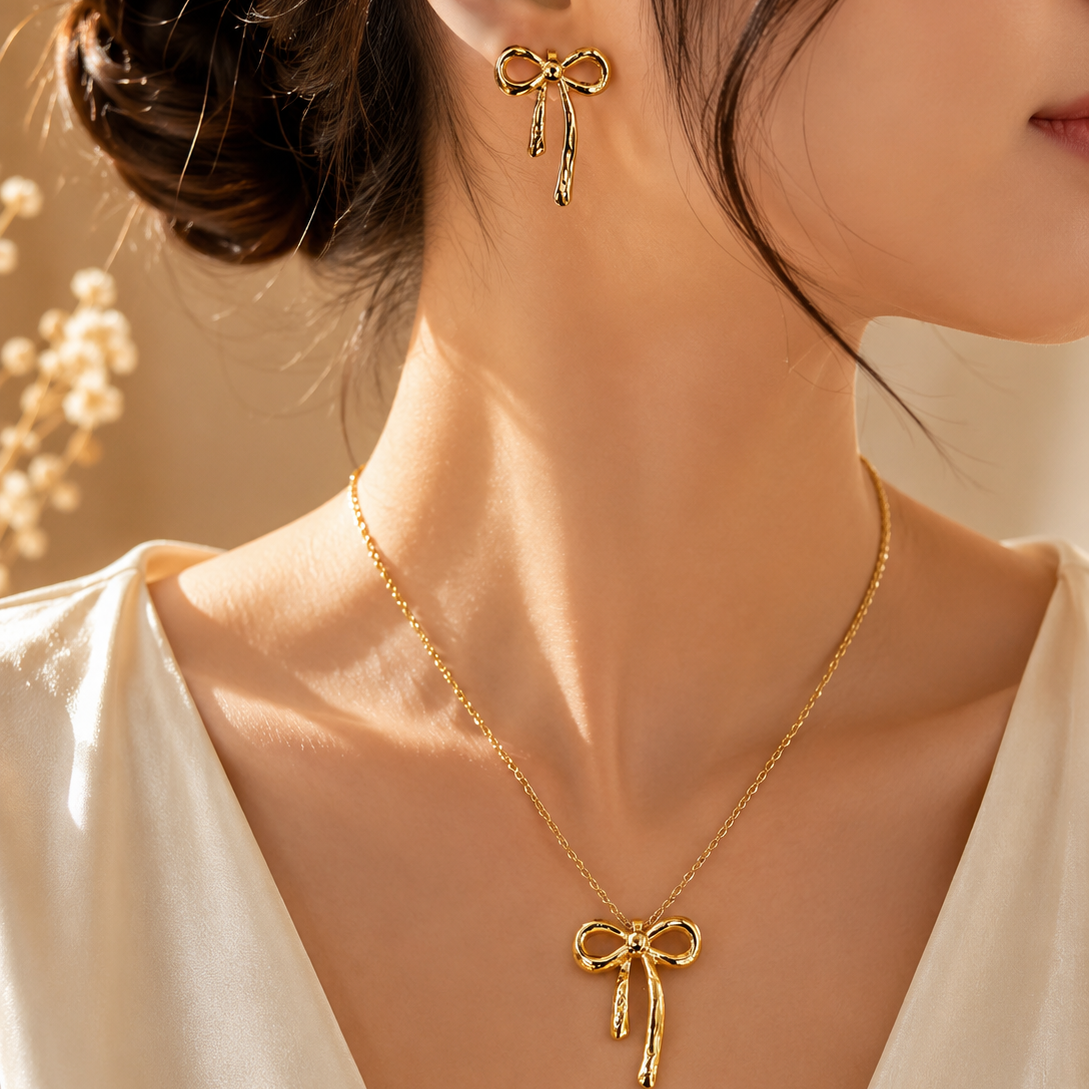 Woman wearing a premium stainless steel gold bow necklace and matching bow earrings