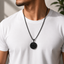 A man wearing a black basketball pendant necklace on a black chain at qatar