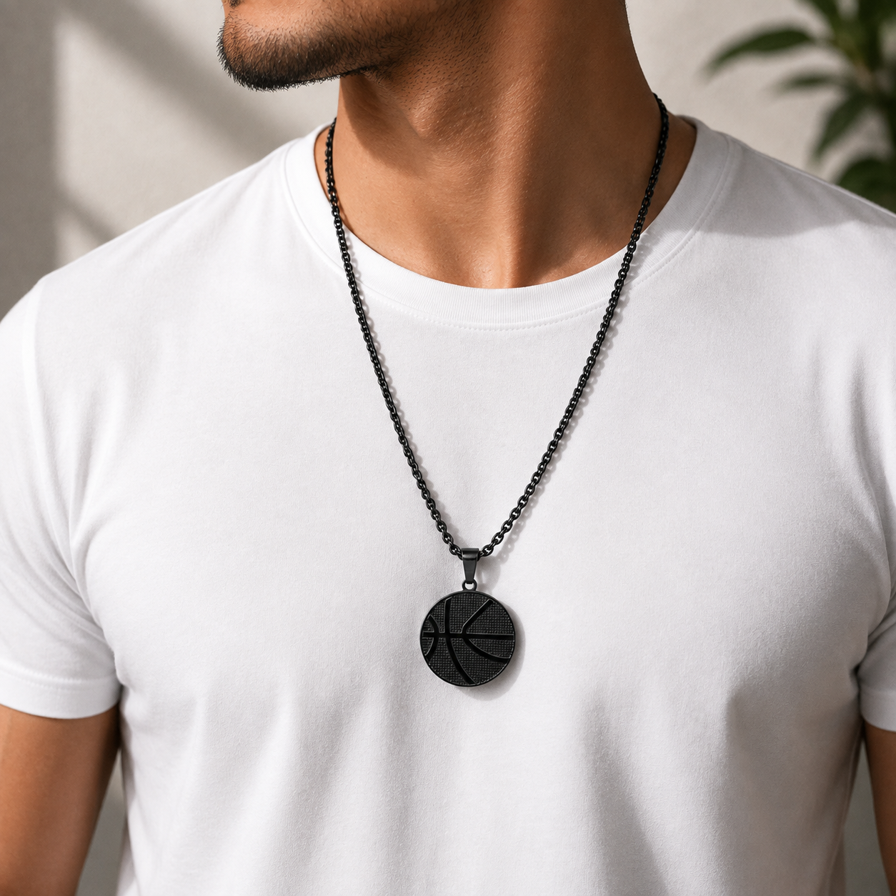 A man wearing a black basketball pendant necklace on a black chain at qatar