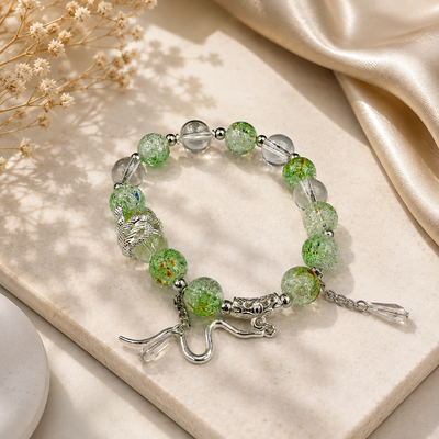 Green and clear beaded women's bracelet with snake charm